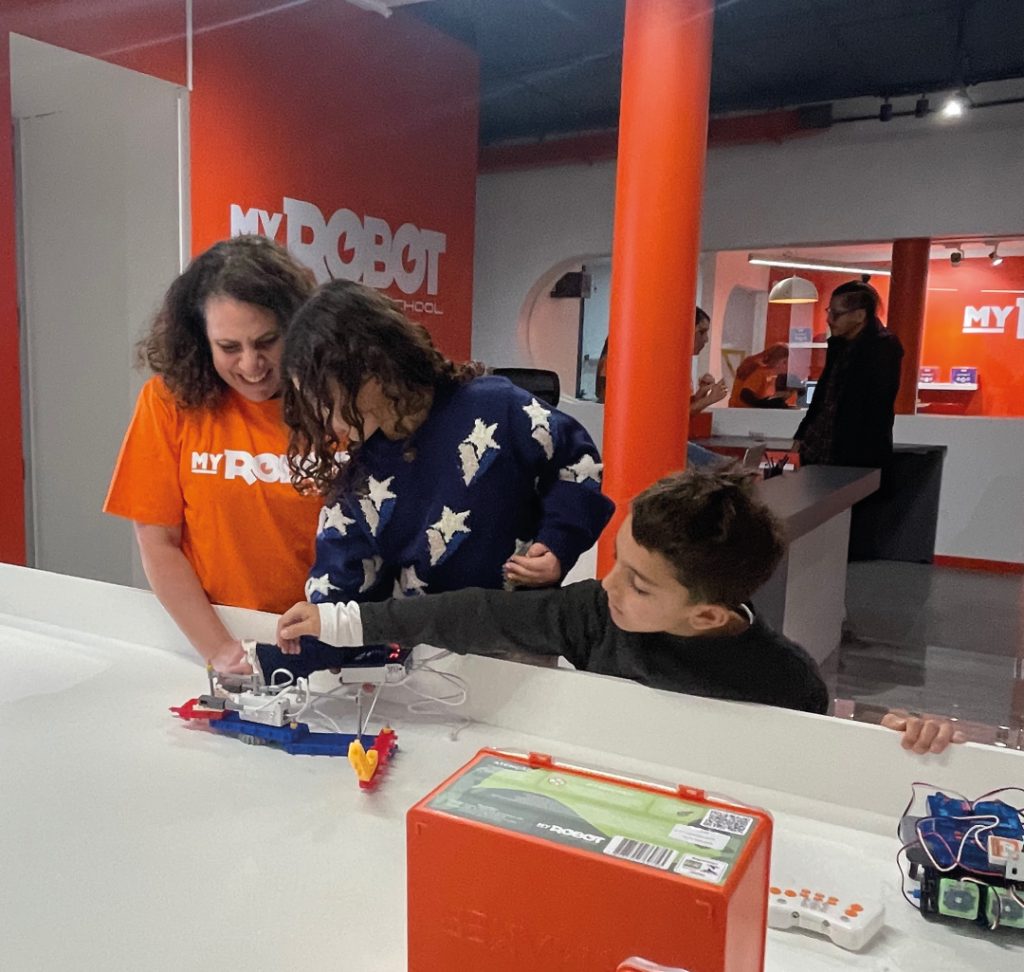 Maestra y alumnos probando el robot